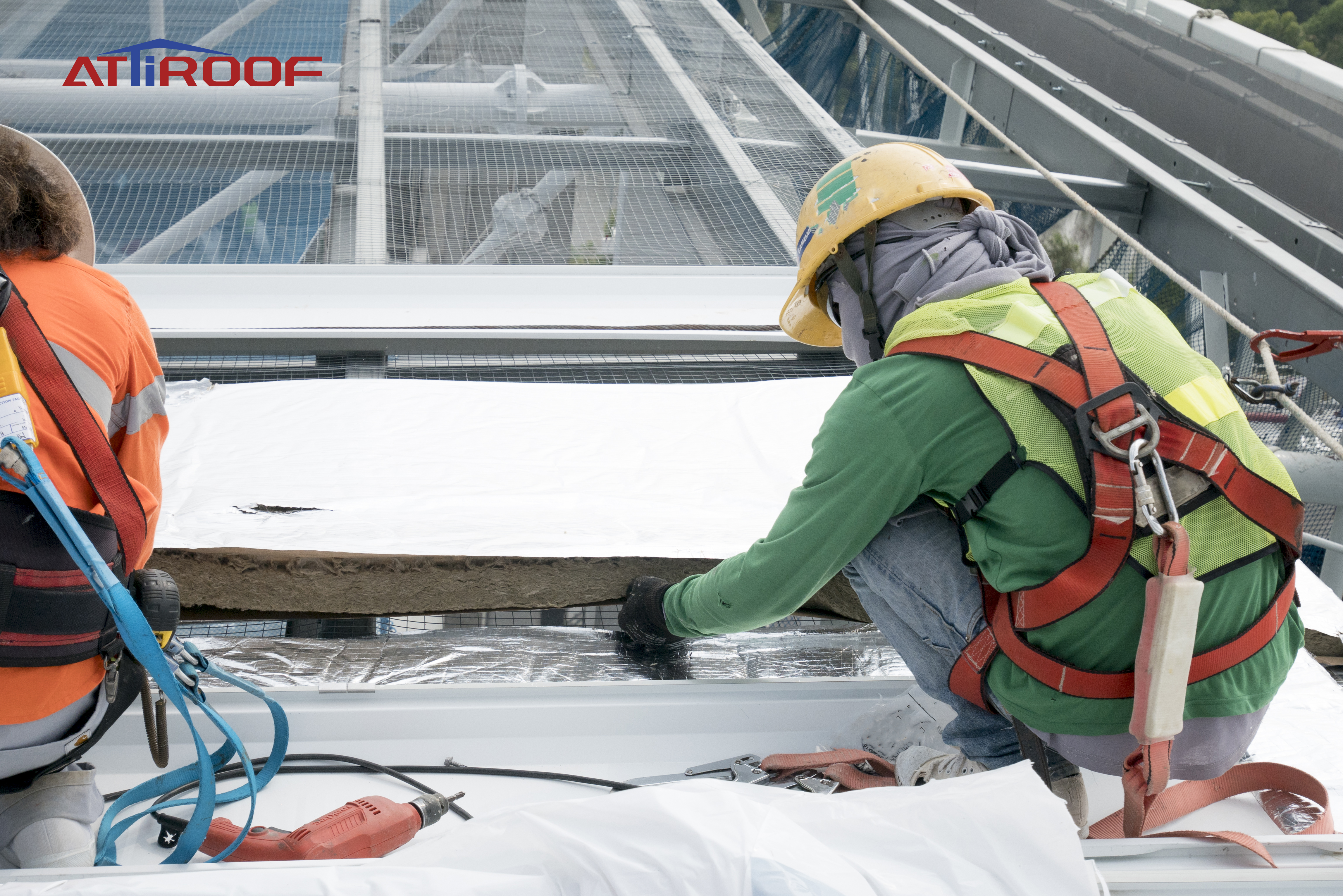 Trabalhadores de telhado com arneses de segurança instalando materiais de telhado, demonstrando precauções de segurança em um canteiro de obras no telhado. Trabalhadores de telhado com arneses de segurança instalando materiais de telhado, demonstrando precauções de segurança em um canteiro de obras no telhado.