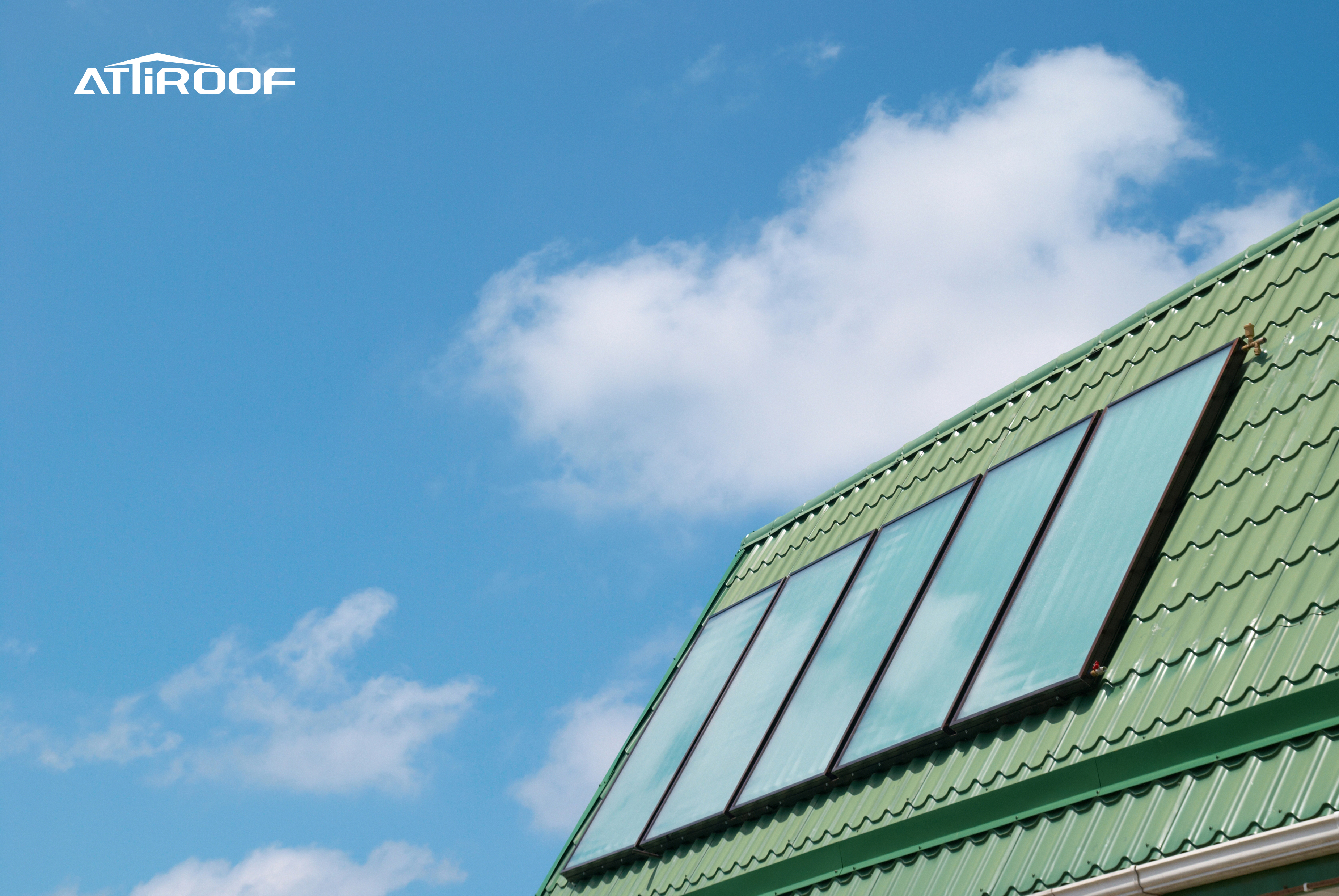 Telhas verdes de resina sintética em um edifício que atende aos padrões de construção verde contra um céu azul com nuvens. Telhas verdes de resina sintética em um edifício que atende aos padrões de construção verde contra um céu azul com nuvens.