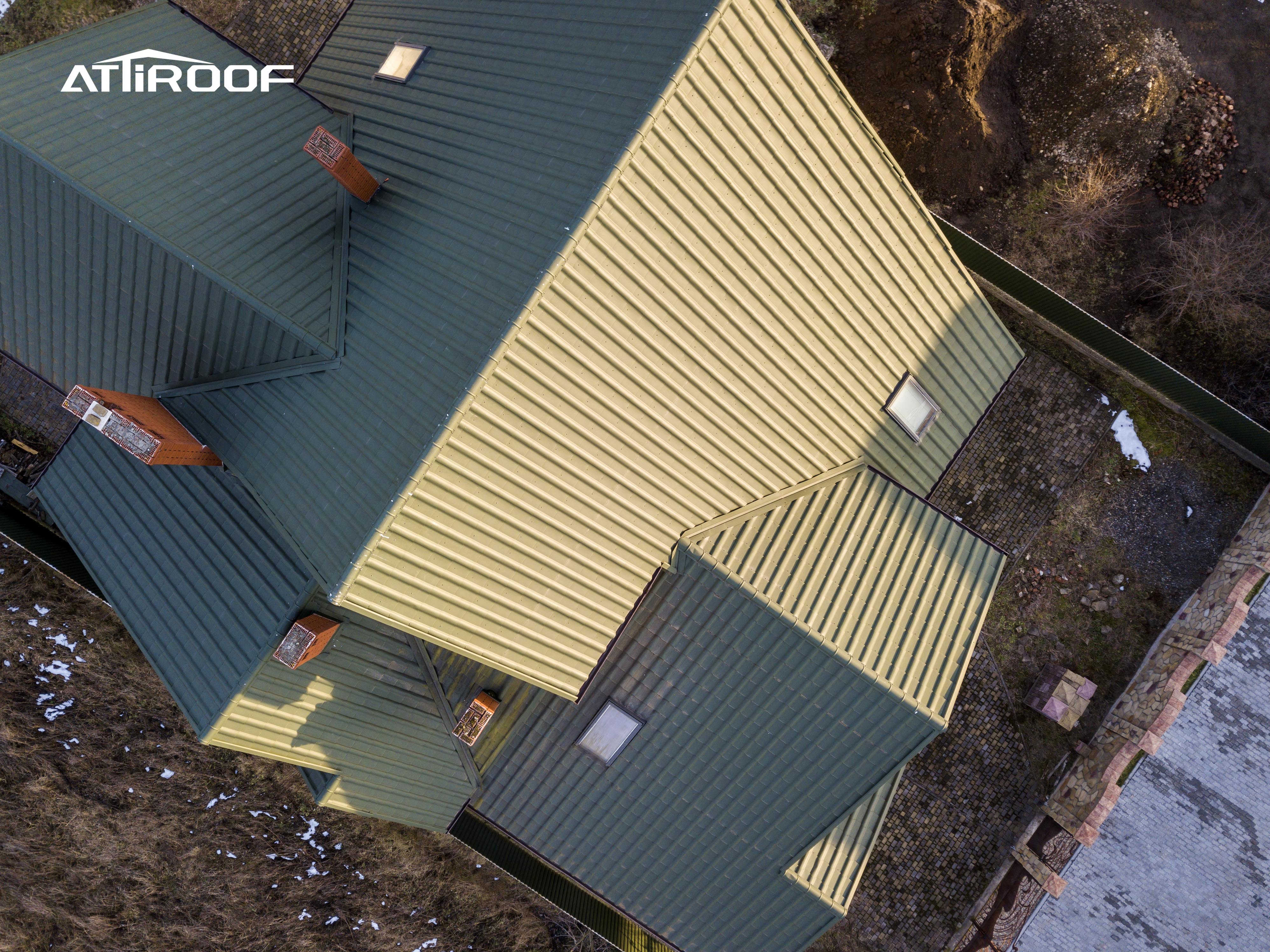 Vista aérea de um edifício com telhas verdes de resina sintética, perfeitamente integradas ao entorno natural. Vista aérea de um edifício com telhas verdes de resina sintética, perfeitamente integradas ao entorno natural.