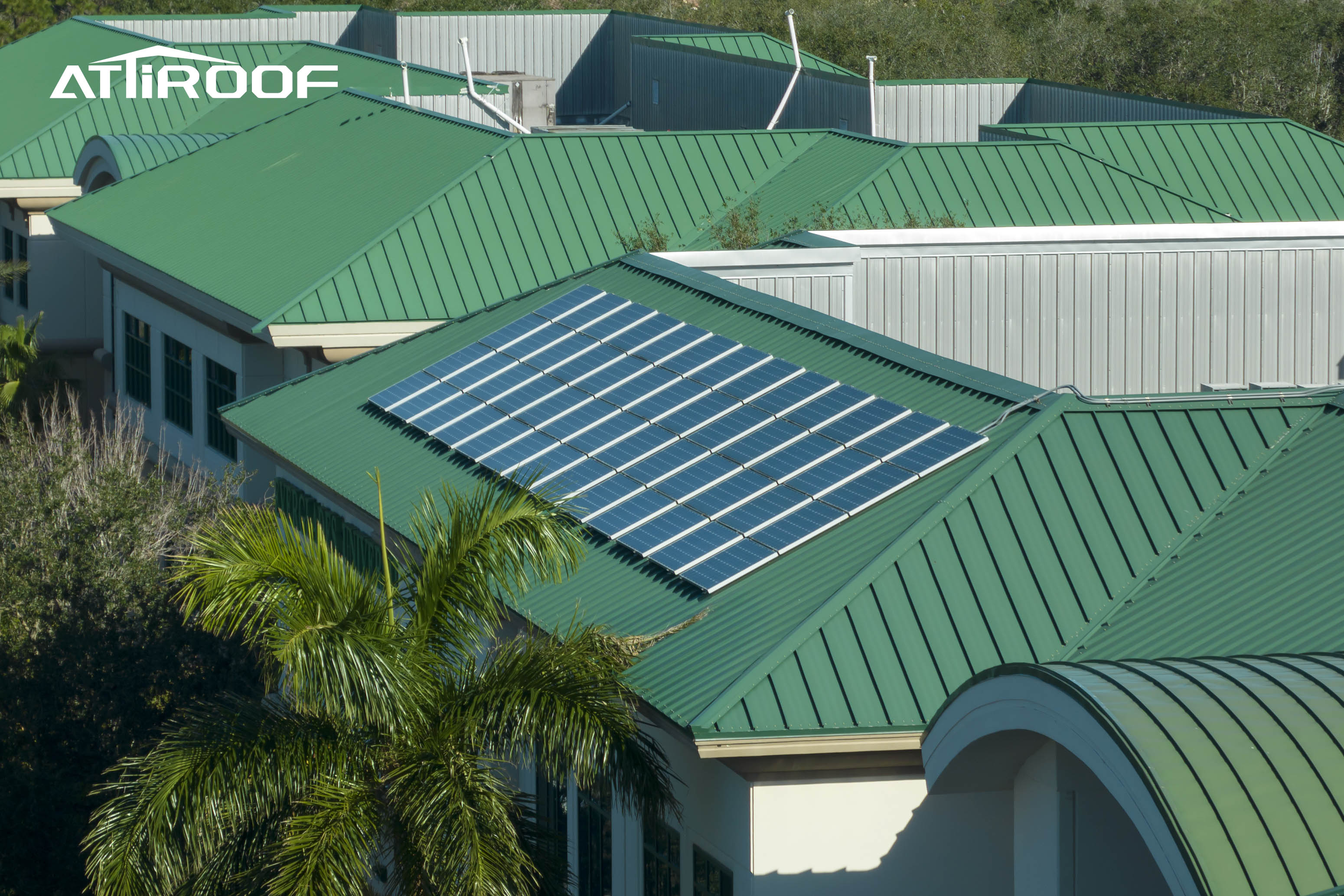 Tendência moderna de coberturas mostrando telhas verdes de resina sintética integradas com painéis solares em um edifício comercial. Tendência moderna de coberturas mostrando telhas verdes de resina sintética integradas com painéis solares em um edifício comercial.