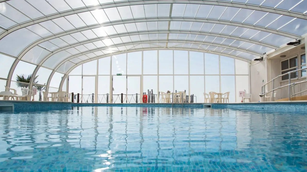 Piscina interior com cobertura em policarbonato transparente.